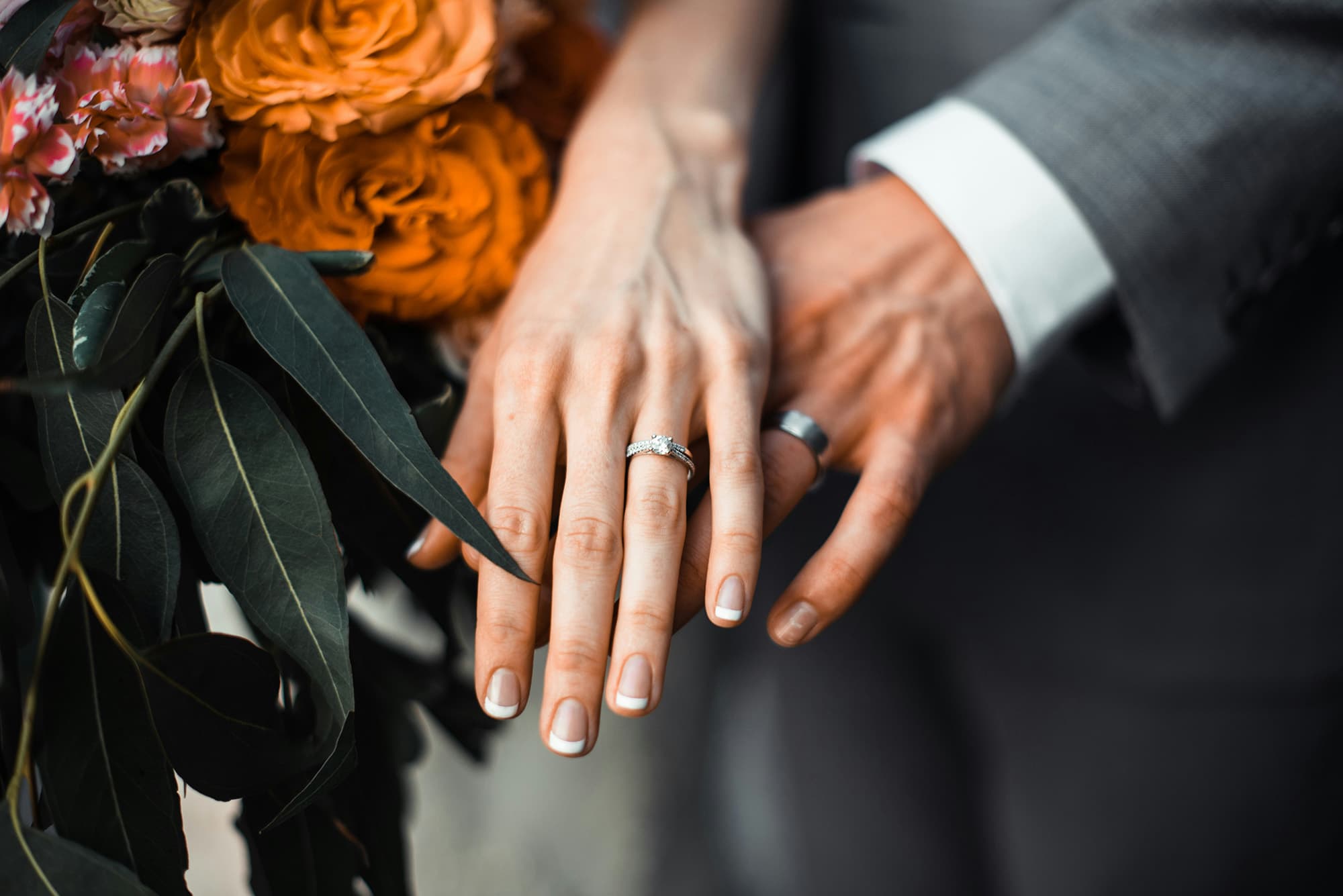 Hochzeitsringe an den Händen eines Mannes und einer Frau